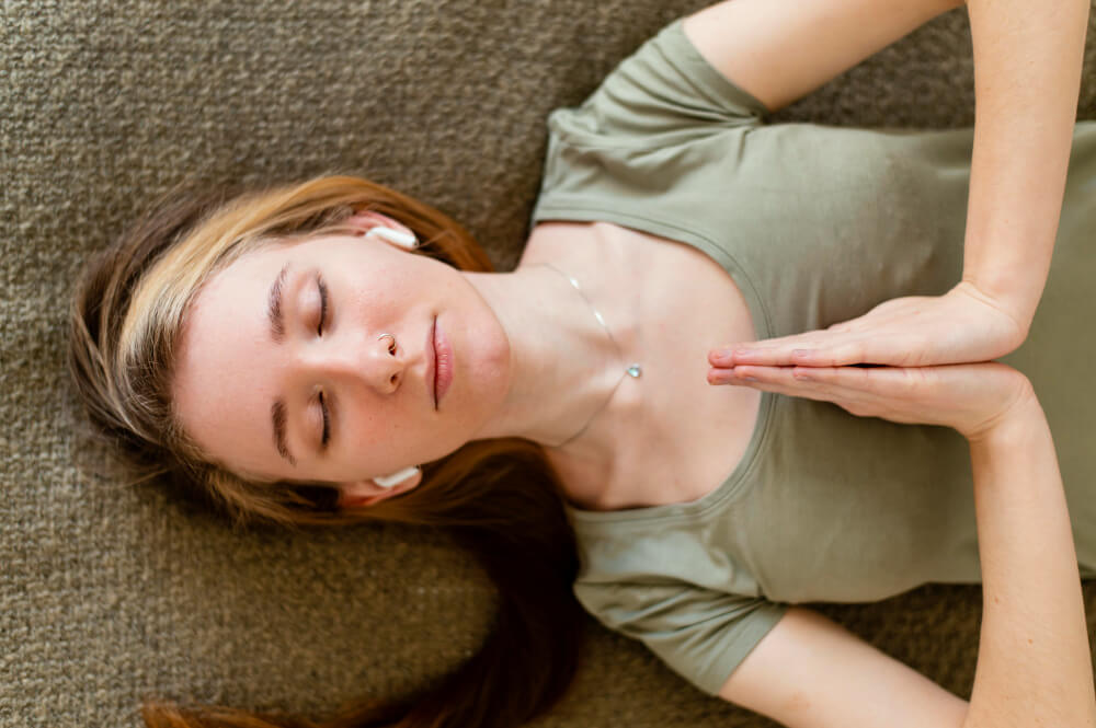 woman doing face yoga and meditating on the floor