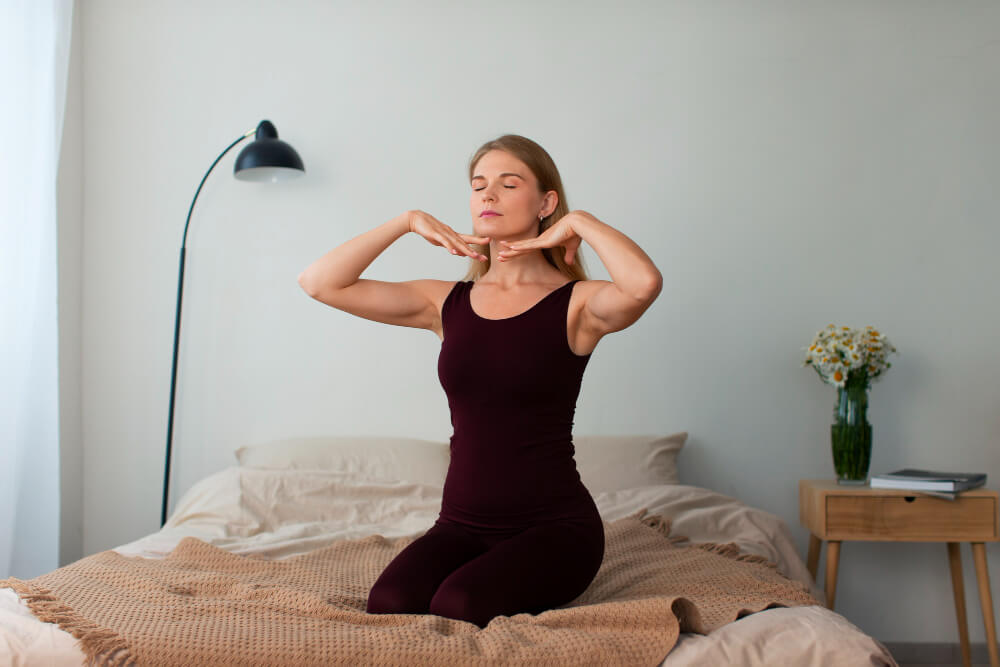 woman on her bed doing face yoga